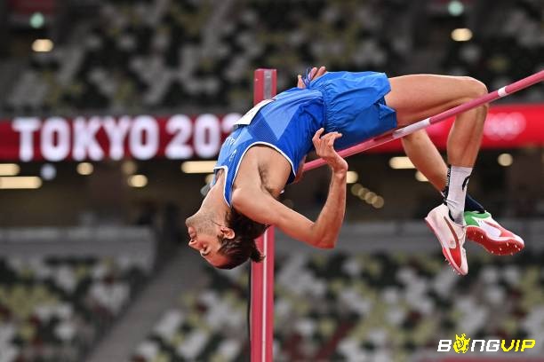 Vận động viên thi đấu giải nhảy cao Olympic trên sân vận động lớn